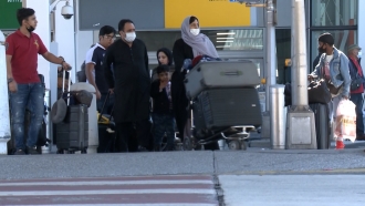 Travelers arrive at JFK International Airport