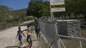 Children walk past the Christian Aid Ministries headquarters in Titanyen