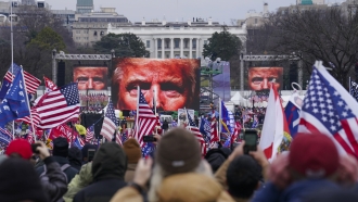 President Donald Trump's face appears on large screens as supporters participate in a rally in Washington