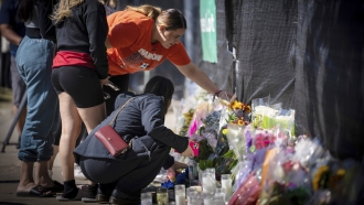 People lay flowers at a memorial for Astroworld victims.