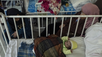 Babies sleep next to their mothers as they undergo treatment for malnutrition in Kabul