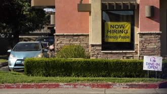 A hiring sign hangs in the window of a Taco Bell in Sacramento, Calif., on July 15, 2021.
