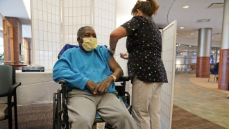 A resident at a nursing home receives a COVID-19 booster shot