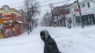 A person walks through the snow to get to work at a restaurant in Providence, R.I.