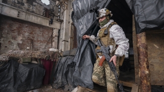 A Ukrainian serviceman walks in the ruins of an industrial compound