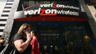 A cell phone user passes a Verizon store in New York.