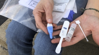 A woman displays an HIV testing kit.