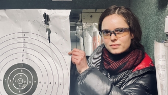 A woman holds a shooting target