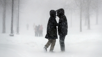 A couple walks through the snow on Boston Common