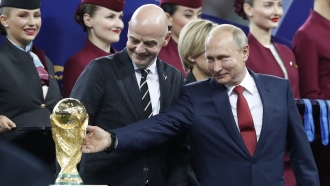 Russian President Vladimir Putin touches the World Cup trophy.