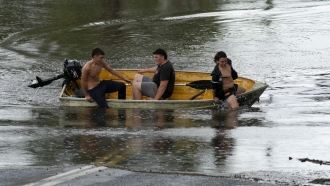 Young boys get off boat in flooded Australian street
