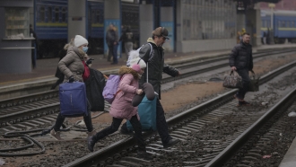 A family runs over train tracks in Kyiv, Ukraine