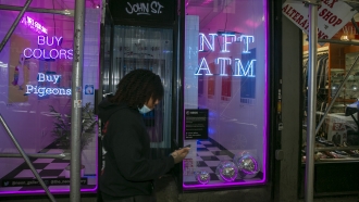 A person walks by a non-fungible token vending machine.