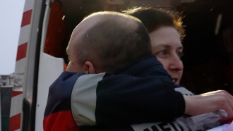 Polish and Ukrainian paramedics embrace each other