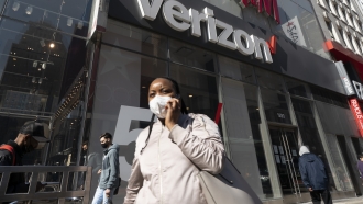 Woman uses mobile phone in front of Verizon store