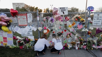 People light candles at a makeshift memorial outside Marjory Stoneman Douglas High School