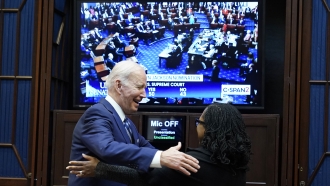 President Joe Biden goes to hug Supreme Court nominee Judge Ketanji Brown Jackson as they watch the Senate vote.