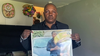 Peter Lyoya holds a picture of his son Patrick Lyoya