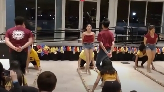 Students perform the traditional Filipino cultural dance Tinikling