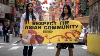 AAPI activists hold a sign
