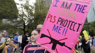 Young girl holds a sign during a 