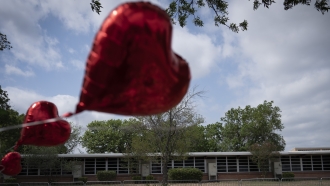A heart-shaped balloon flies decorating a memorial site outside Robb Elementary School in Uvalde, Texas