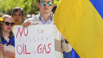 Ukrainian demonstrators demand an embargo on Russian oil during a protest in front of EU institutions