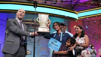 Harini Logan, 14, from San Antonio, Texas, celebrates winning the Scripps National Spelling Bee with Scripps CEO Adam Symson