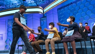, duEkansh Rastogi, 13, from Heathrow, Fla., left, leaves the stage after giving the incorrect meaning of a word