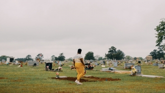 A woman walks in a cemetery.