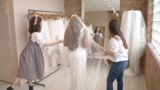 A bride trying on a wedding gown and veil at a bridal shop