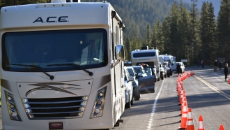 Dozens of vehicles lined up outside Yellowstone National Park’s entrance