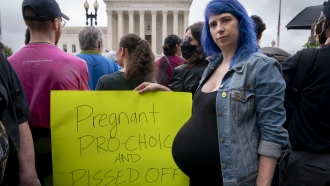 Kiki Fox, 34, of Washington, who is 8 months pregnant, poses for a portrait as she joins abortion rights demonstrators.