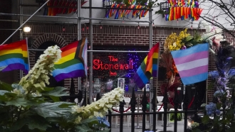 Flags affirming LGBTQ+ identity dress the fencing surrounding the Stonewall National Monument.
