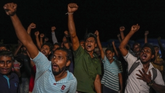 Sri Lankans celebrate as they react to early reports of President Gotabaya Rajapaksa's resignation in Colombo, Sri Lanka.