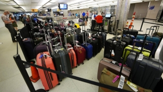 Baggage stacks up from delayed travelers in the baggage claim area of an airport