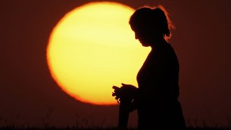 A woman in front of the setting sun