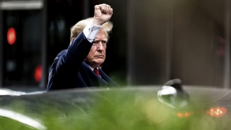 Former President Donald Trump gestures as he departs Trump Tower.