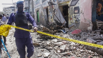 A member of security forces cordons off wreckage at the scene, after gunmen stormed a hotel in the capital Mogadishu, Somalia