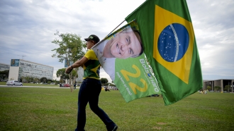 A woman holds a Brazilian flag.