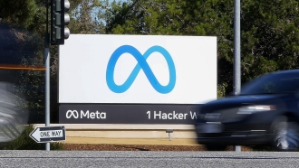 A car passes Facebook's new Meta logo on a sign at the company headquarters