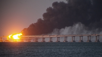 Flame and smoke rise fron Crimean Bridge connecting Russian mainland and Crimean peninsula.
