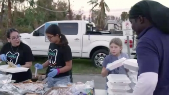 People fill styrofoam food containers.