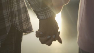 Two people hold hands.