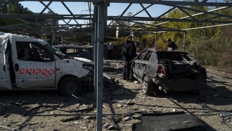 Police officers work at a site where several cars were damaged after a Russian attack in Zaporizhzhia, Ukraine.