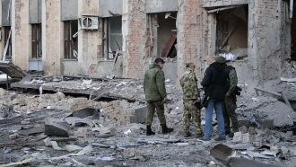 Investigators inspect a site after shelling near an administrative building, in Donetsk, Ukraine.