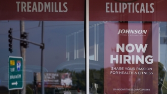 Hiring sign displayed in a business window.