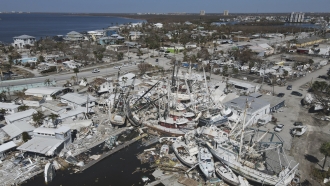 shrimp boats lie grounded atop what was a mobile home park