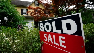 A sale sign stands outside a home in Wyndmoor, Pa.,