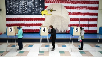 Voters cast their ballots under a giant mural at Robious Elementary School in Midlothian, Va.